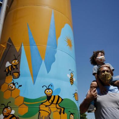 GRAVATAÍ, RS, BRASIL - 17.02.2022 - A caixa dágua da Escola Municipal de Ensino Infantil Favo de Mel, em Gravataí, recebeu uma pintura no início de fevereiro. Inspirado e auxiliado pelo filho e aluno da escola, o artista visual Waldemar Maximílio Barbosa da Silva pintou abelhas e favos de mel no reservatório ¿ a pintura tem cerca de 4m de altura. A arte veio da imaginação do pequeno Iberê Obi Lopes da Silva, de quatro anos: ao ver o reservatório pela primeira vez, disse para o pai que parRBS)rBS)Indexador: Mateus Bruxel<!-- NICAID(15019218) -->