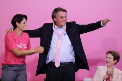 Brazilian President Jair Bolsonaro wears a pink tie next to First Lady Michelle Bolsonaro during a ceremony marking International Womens Day at Planalto Palace, in Brasília, on March 8, 2022. (Photo by Sergio Lima / AFP)<!-- NICAID(15036074) -->