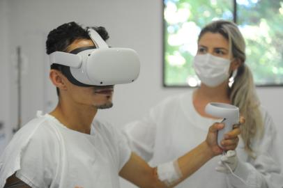 CAXIAS DO SUL, RS, BRASIL 08/03/2022. Realidade virtual é ferramenta para reabilitação de pacientes no Hospital do Círculo, em Caxias do Sul. Na foto, Daniele de Gasperi, fisioterapeuta do Hospital do Círculo e  Johnatan Machado dos Santos, 29, paciente em UTI que experimentou o equipamento. (Bruno Todeschini/Agência RBS)<!-- NICAID(15036044) -->