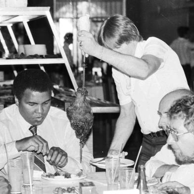 CRÉDITO: OLDERIGE ZARDO - AGÊNCIA RBS-PORTO ALEGRE, RS, BRASIL, 29/04/1987  (OLDERIGE ZARDO - AGÊNCIA RBS) -Muhammad Ali, Classius Clay, em uma churrascaria de Porto Alegre no ano de 1987.Muhammad Ali esteve em Porto Alegre para visitar a fabricante de carros Miura.-#Envelope: 55417#Pasta: 15515#Fotógrafo: Olderige Zardo<!-- NICAID(9196723) -->