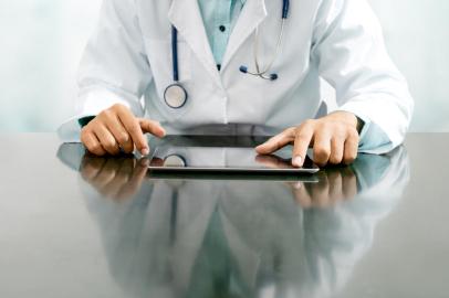 Doctor with tablet computer at hospital office.Médico, consulta, consultório. Foto: Blue Planet Studio  / stock.adobe.comFonte: 227413167<!-- NICAID(15038060) -->