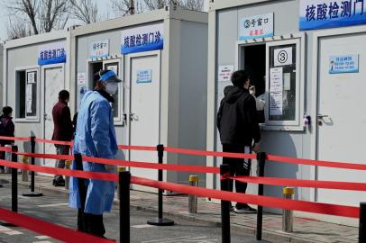 A health worker gets a swab sample on a woman to be tested for Covid-19 coronavirus at a swab collection site in Beijing on March 20, 2022. (Photo by Noel Celis / AFP)Editoria: HTHLocal: BeijingIndexador: NOEL CELISSecao: diseaseFonte: AFPFotógrafo: STF<!-- NICAID(15046320) -->