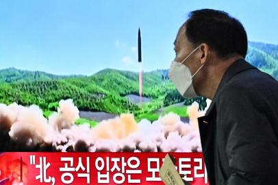 A man walks past a television report showing a news broadcast with file footage of a North Korean missile test, at a railway station in Seoul on March 24, 2022. - North Korea fired an intercontinental ballistic missile (ICBM) on March 24, South Koreas President Moon Jae-in said, the first time Pyongyang has launched such a powerful weapon since 2017. (Photo by Anthony WALLACE / AFP)<!-- NICAID(15049538) -->