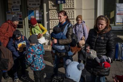 Women with children are seen outside the main railway station in Przemysl, southeastern Poland, near the Polish-Ukrainian border, as refugees from Ukraine wait to get on buses to other destinations in Poland, on March 24, 2022, following Russias invasion of Ukraine. - Over half of Ukraines children are displaced after a month of war, the United Nations Childrens Fund (UNICEF) said. (Photo by Angelos Tzortzinis / AFP)<!-- NICAID(15049550) -->