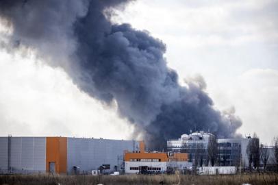 This photograph taken on March 24, 2022 shows smoke raising from a burning warehouse hit by a Russian shell in the suburbs of kyiv. (Photo by FADEL SENNA / AFP)<!-- NICAID(15050802) -->