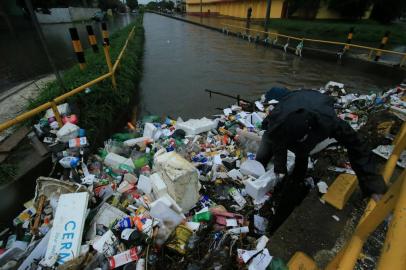 PORTO ALEGRE, RS, BRASIL,  30/03/2022- Tempo chuvoso deixa ruas alagadas na capital. Avenida Sarandi com R. Zeferino Dias. Arroio Sarandi trasnborda e homem se arrisca tentando retirar o lixo. Foto: Ronaldo Bernardi / Agencia RBS<!-- NICAID(15054918) -->