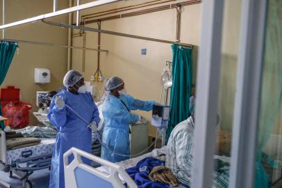 Two nurses are seen next to a machine that check oxygen levels of a A patient infected with COVID-19 at ward number 20 of the Tembisa Hospital in Tembisa, on March 2, 2021. (Photo by Guillem Sartorio / AFP)Editoria: HTHLocal: TembisaIndexador: GUILLEM SARTORIOSecao: diseaseFonte: AFPFotógrafo: STR<!-- NICAID(15055064) -->