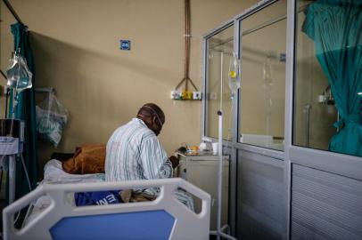 A patient infected with COVID-19 eats while sitting on his bed at ward number 20 of the Tembisa Hospital in Tembisa, on March 2, 2021. (Photo by Guillem Sartorio / AFP)Editoria: HTHLocal: TembisaIndexador: GUILLEM SARTORIOSecao: diseaseFonte: AFPFotógrafo: STR<!-- NICAID(15055065) -->