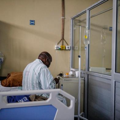 A patient infected with COVID-19 eats while sitting on his bed at ward number 20 of the Tembisa Hospital in Tembisa, on March 2, 2021. (Photo by Guillem Sartorio / AFP)Editoria: HTHLocal: TembisaIndexador: GUILLEM SARTORIOSecao: diseaseFonte: AFPFotógrafo: STR<!-- NICAID(15055065) -->