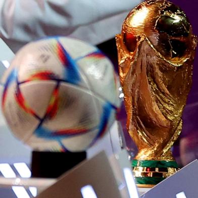 The official 2022 World Cup ball called Al-Rihla, which means the journey in Arabic, and the FIFA World Cup trophy are seen on stage during the draw for the 2022 World Cup in Qatar at the Doha Exhibition and Convention Center on April 1, 2022. (Photo by KARIM JAAFAR / AFP)Editoria: SPOLocal: DohaIndexador: KARIM JAAFARSecao: soccerFonte: AFPFotógrafo: STR<!-- NICAID(15057651) -->