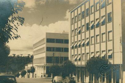 Esquina da Av. Júlio de Castilhos com a Rua Alfredo Chaves por volta de 1954. Vê-se os prédios da antiga Brazex Aços Máquinas, pertencente à Metalúrgica Gazola (Edifício Brazex) e o Edifício Pizzamiglio (em primeiro plano).<!-- NICAID(14998430) -->