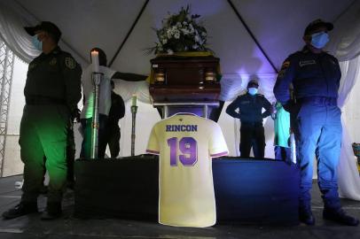 Police stand around the coffin with the remains of Colombian former football player Freddy Rincón in Buenaventura, Colombia, on April 14, 2022. - Colombian former international midfield star Freddy Rincon died on April 13 aged 55 of injuries he sustained in a traffic accident, doctors said. (Photo by Paola Mafla / AFP)<!-- NICAID(15070065) -->