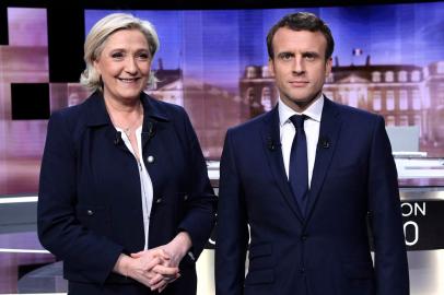 (FILES) In this file photo taken on May 3, 2017 French presidential election candidate for the far-right Front National (FN) party, Marine Le Pen (L) and French presidential election candidate for the En Marche ! movement, Emmanuel Macron pose prior to the start of a live brodcast face-to-face televised debate on the French public national television channel France 2, and French private channel TF1 in La Plaine-Saint-Denis, north of Paris, as part of the second round election campaign. - French President and La Republique en Marche (LREM) party candidate for re-election Emmanuel Macron will go head-to-head with French far-right party Rassemblement National (RN) presidential candidate Marine Le Pen late on April 20, 2022 in their only direct clash ahead of April 24s second-round vote, an encounter set to be watched by millions of French people. (Photo by Eric Feferberg / POOL / AFP) / ALTERNATIVE CROP<!-- NICAID(15072340) -->