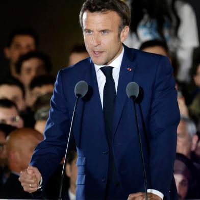 French President and La Republique en Marche (LREM) party candidate for re-election Emmanuel Macron gestures as he delivers a speech after his victory in Frances presidential election, at the Champ de Mars in Paris, on April 24, 2022. (Photo by Ludovic MARIN / AFP)<!-- NICAID(15076912) -->