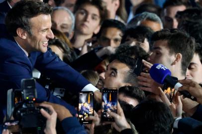 French President and La Republique en Marche (LREM) party candidate for re-election Emmanuel Macron (L) greets supporters after his victory in Frances presidential election, at the Champ de Mars in Paris, on April 24, 2022. (Photo by Ludovic MARIN / AFP)<!-- NICAID(15076914) -->