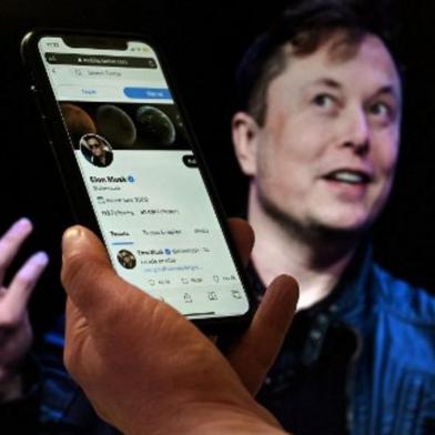 (FILES) In this file photo taken on April 14, 2022 In this photo illustration, a phone screen displays the Twitter account of Elon Musk with a photo of him shown in the background, on April 14, 2022, in Washington, DC. - Musk has lined up $46.5 billion in financing for a possible hostile takeover of Twitter and is exploring a direct tender offer to shareholders, according to a securities filing released on April 21, 2022. Musks filing pointed to a $13 billion debt facility from a financing consortium led by Morgan Stanley, a separate $12.5 billion margin loan from the same bank, as well as $21 billion in equity commitments from Musk himself. (Photo by Olivier DOULIERY / AFP)<!-- NICAID(15077552) -->