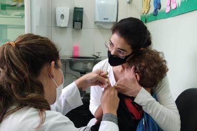 Os postos de saúde  estão abertos desde às 8h deste sábado (30) em Caxias do Sul para o Dia D da vacinação. São aplicadas doses da vacina contra o sarampo e a gripe (Influenza). Até o final da manhã, o movimento era tranquilo nas unodades básicas de saúde do bairro Cruzeiro, Centro e Cinquentenário. Na UBS Cruzeiro, 30 crianças de seis meses a quatro anos e 11 meses já haviam sido vacinadas antes das 11h. Os pequenos fizeram as duas vacinas: da gripe e do sarampo. Na foto: a administradora Janaína Maria de Oliveira Aguiar Orlando, 44 anos, que levou o filho  Joaquim Aguiar Orlando, três anos e meio para fazer as vacinas.<!-- NICAID(15082709) -->