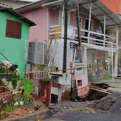 Nove moradores tiveram que deixar as casas em Caxias do Sul após a chuva intensa que atingiu a cidade. Três delas foram retiradas de uma residência na Rua Luiz Antônio de Oliveira, no bairro Cidade Nova, ainda na noite de segunda-feira (2). Nessa terça (3), mais seis pessoas saíram da casa que fica ao lado da interditada na segunda. Ali o asfalto cedeu e o muro da casa começou a cair para o lado. A Defesa Civil acionou a Secretaria de Obras para verificar se houve o rompimento de uma galeria de esgoto no local, porque foram realizadas obras naquele trecho há cerca de um mês.  No Planalto, na Rua Gigia Bandera, o asfalto de uma rua desmoronou em cima de casa. A residência estava vazia e ninguém se feriu. O motorista de aplicativo Márcio Antônio de Matos, 39 anos, se preparava para sair de casa. A proprietária da casa morava no térreo, onde também tem um salão de beleza: <!-- NICAID(15084978) -->