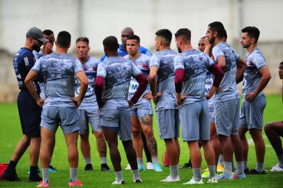 CAXIAS DO SUL, RS, BRASIL, 04/04/2022. A SER Caxias apresentou na tarde desta segunda-feira o novo técnico para a temporada 2022. O técnico Luan Carlos e o auxiliar Kinho Forgiarini já comandaram um treino no CT Baixada Rubra/Vanderlei Bersaghi. Na foto, técnico Luan Carlos (de boné) conversa com jogadores. (Porthus Junior/Agência RBS)<!-- NICAID(15059785) -->