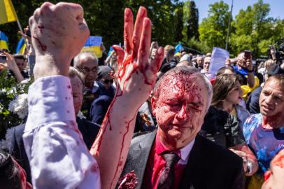 Embaixador russo na Polônia, o embaixador Sergey Andreev reage após ser coberto com tinta vermelha durante um protesto antes de uma cerimônia no mausoléu de guerra do soldado soviético em Varsóvia, Polônia, em 9 de maio de 2022, no dia do 77º aniversário da vitória soviética de 1945 contra Alemanha nazista. (Foto de Wojtek RADWANSKI / AFP)<!-- NICAID(15091363) -->