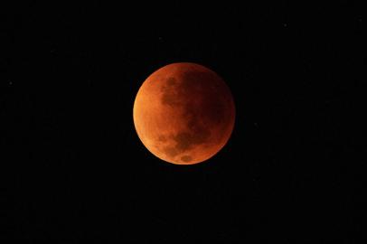 The blood moon is seen during a total lunar eclipse in Rio de Janeiro on May 16, 2022. (Photo by CARL DE SOUZA / AFP)<!-- NICAID(15096917) -->