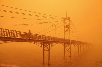 A man walks along a pedestrian bridge along the Euphrates river in the city of Nasiriyah in Iraqs southern Dhi Qar province on May 16, 2022 amidst a heavy dust storm. (Photo by Asaad NIAZI / AFP) / The erroneous mention[s] appearing in the metadata of this photo has been modified in AFP systems in the following manner: BYLINE [Asaad NIAZI] instead of [Sabah ARAR]. Please immediately remove the erroneous mention[s] from all your online services and delete it (them) from your servers. If you have been authorized by AFP to distribute it (them) to third parties, please ensure that the same actions are carried out by them. Failure to promptly comply with these instructions will entail liability on your part for any continued or post notification usage. Therefore we thank you very much for all your attention and prompt action. We are sorry for the inconvenience this notification may cause and remain at your disposal for any further information you may require.Editoria: WEALocal: NasiriyahIndexador: ASAAD NIAZISecao: reportFonte: AFPFotógrafo: STR<!-- NICAID(15097137) -->