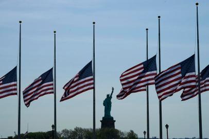 US flags, across New York Bay from the Statue of Liberty, fly at half-mastat Liberty State Park in Jersey City, New Jersey, on May 25, 2022, as a mark of respect for the victims of the May 24 shooting at Robb Elementary School in Uvalde, Texas. - A teenage gunman killed at least 19 young children and two teachers at the elementary school on May 24, prompting President Joe Biden to denounce the US gun lobby and vow to end the nations cycle of mass shootings. (Photo by TIMOTHY A. CLARY / AFP)<!-- NICAID(15106239) -->