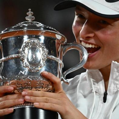 Polands Iga Swiatek poses with the trophy after winning against US Coco Gauff at the end of their womens single final match on day fourteen of the Roland-Garros Open tennis tournament at the Court Philippe-Chatrier in Paris on June 4, 2022. - Iga Swiatek cruised to her second French Open title by dominating teenager Coco Gauff in the final as the world number one claimed her 35th successive victory. (Photo by Anne-Christine POUJOULAT / AFP)<!-- NICAID(15115585) -->