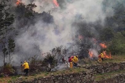 Foto divulgada pela Prefeitura de Machu Picchu mostrando bombeiros trabalhando para apagar um incêndio no mato que cerca as ruínas de Llamakancha, um setor no sítio arqueológico de Machu Picchu, a joia inca da indústria de viagens do Peru, nas terras altas próximas ao cidade de Cusco, em 28 de junho de 2022. (Foto de Jesus TAPIA / Município de Machu Picchu / AFP) / RESTRITO AO USO EDITORIAL - CRÉDITO OBRIGATÓRIO FOTO AFP / MUNICÍPIO DE MACHU PICCHU / JESUS ¿¿TAPIA - SEM MARKETING - SEM CAMPANHAS PUBLICITÁRIAS - DISTRIBUÍDO COMO UM SERVIÇO AOS CLIENTES<!-- NICAID(15137961) -->