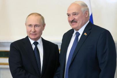 Russian President Vladimir Putin (L) shakes hands with his Belarusian counterpart Alexander Lukashenko during their meeting in Saint Petersburg, on June 25, 2022. (Photo by Mikhail Metzel / SPUTNIK / AFP)<!-- NICAID(15138555) -->