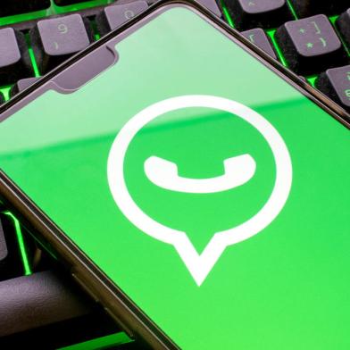 Mobile phone with green whatsapp logo on display and colorful illuminated keyboard close up. Smartphone concept using the messaging application with the symbol on screenFonte: 412314109<!-- NICAID(15140084) -->