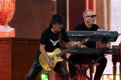 Carlos Santana (L) performs with Marin Alsop and the New York Philharmonic during the We Love NYC: The Homecoming Concert in Central Park on August 21, 2021 in New York City. - Bruce Springsteen, Patti Smith and Paul Simon are set to headline a massive Central Park concert Saturday meant to signal New York Citys homecoming in the wake of the pandemics worst devastation there. (Photo by Kena Betancur / AFP)<!-- NICAID(14869001) -->