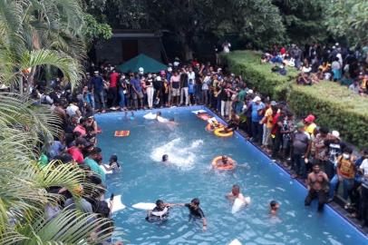 Protestors demanding the resignation of Sri Lankas President Gotabaya Rajapaksa swim in a pool inside the compound of Sri Lankas Presidential Palace in Colombo on July 9, 2022. - Sri Lankas beleaguered President Gotabaya Rajapaksa fled his official residence in Colombo, a top defence source told AFP, before protesters gathered to demand his resignation stormed the compound. (Photo by AFP)<!-- NICAID(15145572) -->