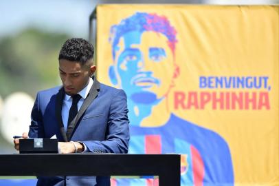 FC Barcelonas new Brazilian forward Raphael Dias Belloli, aka Raphinha, signs contracts during his presentation ceremony  at the Joan Gamper training ground in Sant Joan Despi, near Barcelona, on July 15, 2022. (Photo by Pau BARRENA / AFP)<!-- NICAID(15149751) -->