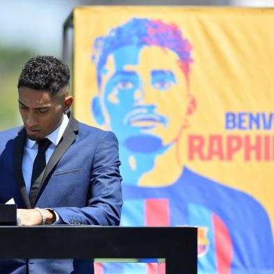 FC Barcelonas new Brazilian forward Raphael Dias Belloli, aka Raphinha, signs contracts during his presentation ceremony  at the Joan Gamper training ground in Sant Joan Despi, near Barcelona, on July 15, 2022. (Photo by Pau BARRENA / AFP)<!-- NICAID(15149751) -->