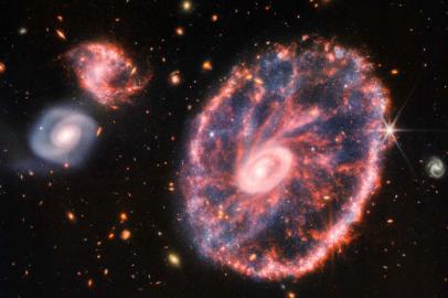 This composite image from Webbs Near-Infrared Camera (NIRCam) and Mid-Infrared Instrument (MIRI) released by NASA on August 2, 2022, shows the Cartwheel and its companion galaxies, revealing details that are difficult to see in the individual images alone. - This galaxy formed as the result of a high-speed collision that occurred about 400 million years ago. The Cartwheel is composed of two rings, a bright inner ring and a colorful outer ring. Both rings expand outward from the center of the collision like shockwaves. This snapshot provides perspective on what happened to the galaxy in the past and what it will do in the future. (Photo by Space Telescope Science Institut / NASA / AFP) / RESTRICTED TO EDITORIAL USE - MANDATORY CREDIT AFP PHOTO / NASA - NO MARKETING NO ADVERTISING CAMPAIGNS - DISTRIBUTED AS A SERVICE TO CLIENTS<!-- NICAID(15165048) -->