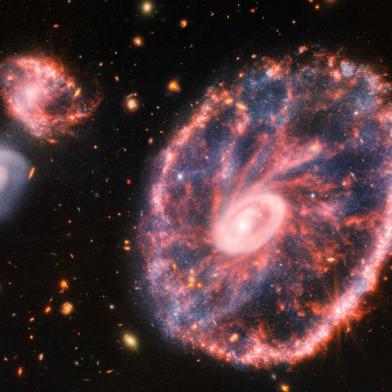 This composite image from Webbs Near-Infrared Camera (NIRCam) and Mid-Infrared Instrument (MIRI) released by NASA on August 2, 2022, shows the Cartwheel and its companion galaxies, revealing details that are difficult to see in the individual images alone. - This galaxy formed as the result of a high-speed collision that occurred about 400 million years ago. The Cartwheel is composed of two rings, a bright inner ring and a colorful outer ring. Both rings expand outward from the center of the collision like shockwaves. This snapshot provides perspective on what happened to the galaxy in the past and what it will do in the future. (Photo by Space Telescope Science Institut / NASA / AFP) / RESTRICTED TO EDITORIAL USE - MANDATORY CREDIT AFP PHOTO / NASA - NO MARKETING NO ADVERTISING CAMPAIGNS - DISTRIBUTED AS A SERVICE TO CLIENTS<!-- NICAID(15165048) -->