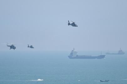 Chinese military helicopters fly past Pingtan island, one of mainland Chinas closest point from Taiwan, in Fujian province on August 4, 2022, ahead of massive military drills off Taiwan following US House Speaker Nancy Pelosis visit to the self-ruled island. - China is due on August 4 to kick off its largest-ever military exercises encircling Taiwan, in a show of force straddling vital international shipping lanes following a visit to the self-ruled island by US House Speaker Nancy Pelosi. (Photo by Hector RETAMAL / AFP)Editoria: POLLocal: PingtanIndexador: HECTOR RETAMALSecao: diplomacyFonte: AFPFotógrafo: STF<!-- NICAID(15166449) -->