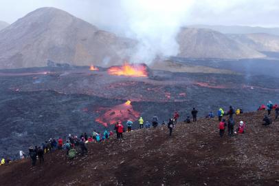 Espectadores e turistas observam os fluxos de lava do vulcão em Fagradalsfjall, Islândia, a cerca de 40 quilômetros da capital Reykjavik, em 10 de agosto de 2022, após uma erupção que está em andamento desde 3 de agosto de 2022. - O vulcão entrou em erupção em 3 de agosto, a cerca de 40 quilômetros (25 milhas) de Reykjavik, perto do local do vulcão Monte Fagradalsfjall, que entrou em erupção por seis meses em março-setembro de 2021, hipnotizando turistas e espectadores que acorreram ao local. (Foto de Jeremie RICHARD/AFP)<!-- NICAID(15172637) -->