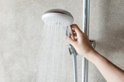 *A PEDIDO DE MARY SILVA* Hand holding shower head during taking shower with wall background in modern bathroom - Foto: Jo Panuwat D/stock.adobe.comFonte: 481086853<!-- NICAID(15159714) -->