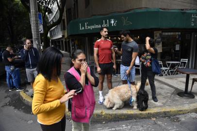 People remain in the street after an earthquake in Mexico City on September 19, 2022. - A 6.8-magnitude earthquake struck western Mexico on Monday, shaking buildings in Mexico City on the anniversary of two major tremors in 1985 and 2017, seismologists said. (Photo by CLAUDIO CRUZ / AFP)Editoria: DISLocal: Mexico CityIndexador: CLAUDIO CRUZSecao: earthquakeFonte: AFPFotógrafo: STR<!-- NICAID(15210717) -->