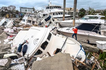 Fox Weather Correspondent Robert Ray takes photos of boats damaged by Hurricane Ian in Fort Myers, Florida, on September 29, 2022. - Hurricane Ian left much of coastal southwest Florida in darkness early on Thursday, bringing catastrophic flooding that left officials readying a huge emergency response to a storm of rare intensity. The National Hurricane Center said the eye of the extremely dangerous hurricane made landfall just after 3:00 pm (1900 GMT) on the barrier island of Cayo Costa, west of the city of Fort Myers. (Photo by Giorgio VIERA / AFP)Editoria: DISLocal: Fort MyersIndexador: GIORGIO VIERASecao: meteorological disasterFonte: AFPFotógrafo: STR<!-- NICAID(15221630) -->