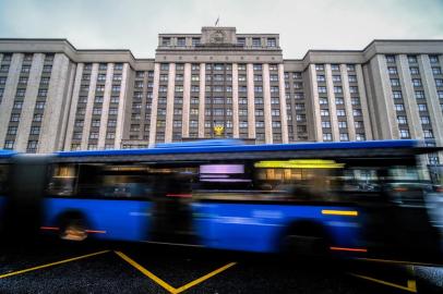 Um ônibus passa em frente ao prédio da Duma do Estado, a câmara baixa do parlamento da Rússia, onde os legisladores devem considerar tratados formalmente anexando quatro regiões da Ucrânia ocupadas por tropas russas - Lugansk, Donetsk, Kherson e Zaporizhzhia, em Moscou em 3 de outubro de 2022. ( Foto de Yuri KADOBNOV / AFP)<!-- NICAID(15225185) -->