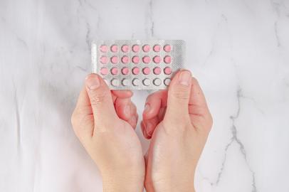 *A PEDIDO DE LUISA TESSUTO* Female hands holding birth control pills on a marble background - Foto: oasisamuel/stock.adobe.comFonte: 302111027<!-- NICAID(15227268) -->