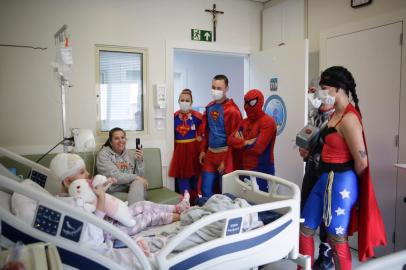 Porto Alegre, RS, Brasil, 12-10-2022: Super-heróis visitam as crianças internadas no Hospital da Criança Santo Antônio em ação no Dia da Criança na instituição. Na foto, a paciente, Sophia da Rosa D¿Avila, 7, e a mãe dela, Clarissa da Rosa com os super-heróis.  Foto: Mateus Bruxel / Agência RBSIndexador: Mateus Bruxel<!-- NICAID(15233723) -->