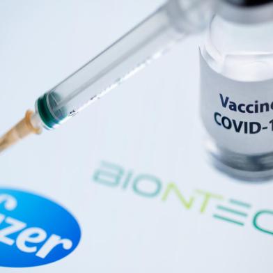 (FILES) In this file photo taken on November 23, 2020 This illustration picture taken on November 23, 2020 shows a bottle reading Vaccine Covid-19 and a syringe next to the Pfizer and Biontech logo. - Britain on December 2, 2020 became the first country to approve Pfizer-BioNTechs Covid-19 vaccine for general use and said it would be introduced next week. (Photo by JOEL SAGET / AFP)Editoria: HTHLocal: ParisIndexador: JOEL SAGETSecao: diseaseFonte: AFPFotógrafo: STF<!-- NICAID(14659604) -->