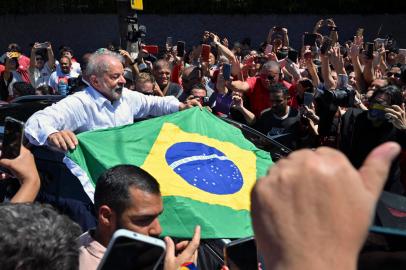 Brazilian former President (2003-2010) and candidate for the leftist Workers Party (PT) Luiz Inacio Lula da Silva unfolds a Brazilian flag while leaving the polling station during the presidential run-off election, in Sao Paulo, Brazil, on October 30, 2022. - After a bitterly divisive campaign and inconclusive first-round vote, Brazil elects its next president in a cliffhanger runoff between far-right incumbent Jair Bolsonaro and veteran leftist Luiz Inacio Lula da Silva. (Photo by NELSON ALMEIDA / AFP)Editoria: POLLocal: Sao PauloIndexador: NELSON ALMEIDASecao: electionFonte: AFPFotógrafo: STF<!-- NICAID(15249961) -->