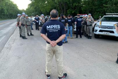 Agente do Ministério Público em evidência e vários outros profissionais do MP e da brigada Militar atrás<!-- NICAID(15267729) -->