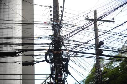 CAXIAS DO SUL, RS, BRASIL, 16/08/2022. Fios inoperantes em postes de energia elétrica na área central de Caxias do Sul serão removidos pela Secretaria de Obras, Trânsito e Urbanismo e pela Rio Grande Energia (RGE) no dia 16 de setembro de 2022. Emaranhados de fios são vistos em postes de energia elétrica na rua Os 18 do Forte no trecho da Alfredo Chaves com Marquês do Herval. (Porthus Junior/Agência RBS)<!-- NICAID(15177460) -->