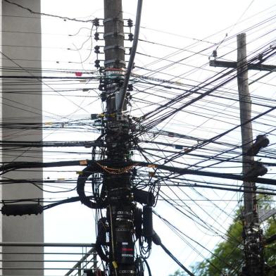 CAXIAS DO SUL, RS, BRASIL, 16/08/2022. Fios inoperantes em postes de energia elétrica na área central de Caxias do Sul serão removidos pela Secretaria de Obras, Trânsito e Urbanismo e pela Rio Grande Energia (RGE) no dia 16 de setembro de 2022. Emaranhados de fios são vistos em postes de energia elétrica na rua Os 18 do Forte no trecho da Alfredo Chaves com Marquês do Herval. (Porthus Junior/Agência RBS)<!-- NICAID(15177460) -->